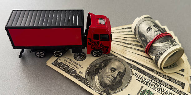 White toy truck lie on dollars, space for text. High quality photo