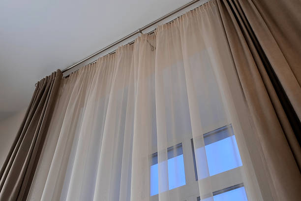 istock Beige curtaing on the window with fine tulle in modern interior, bottom view. 2213672153