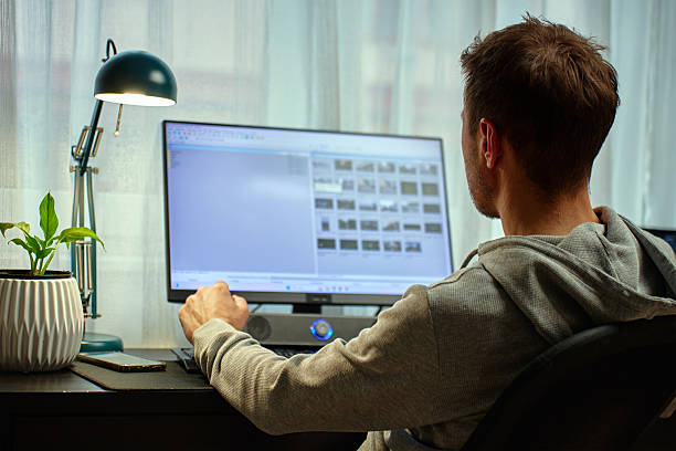 istock Man working from home at desk with computer and lamp 2213672328