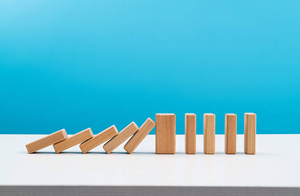 istock Wooden blocks stop other falling dominos 2213673813