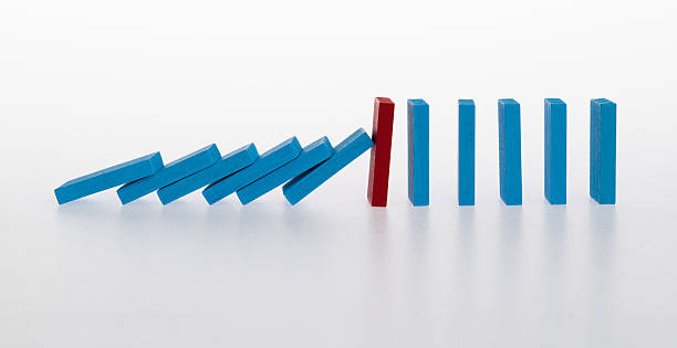 istock Red wooden block stop other falling dominos 2213673827