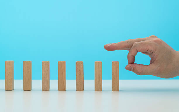 istock Human finger pushing domino pieces 2213673928