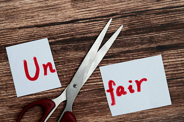 istock Scissor cutting paper with word unfair 2213673946