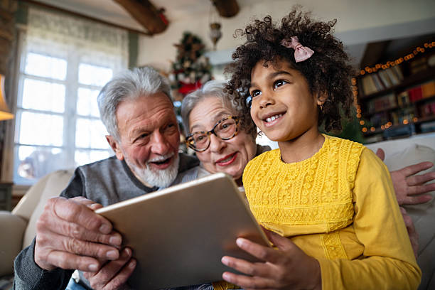 istock Happy senior couple using modern tech gadget tablet together with grandchild at home. 2213674585