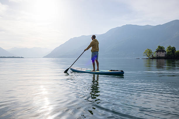 istock Paddleboarder Enjoying Serene Lake at Sunrise 2213678738