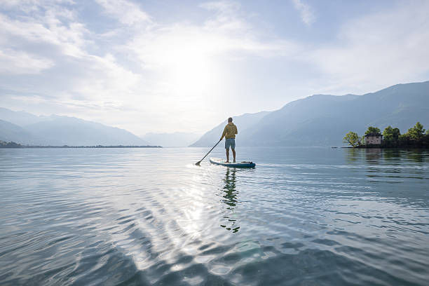 istock Paddleboarder Enjoying Serene Lake at Sunrise 2213678740