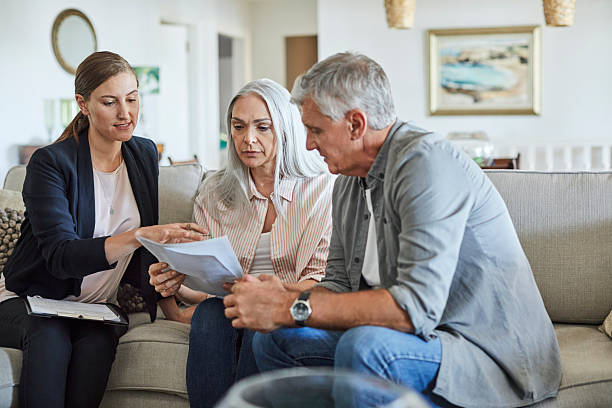 istock Couple discussing with financial advisor at home 2213680091