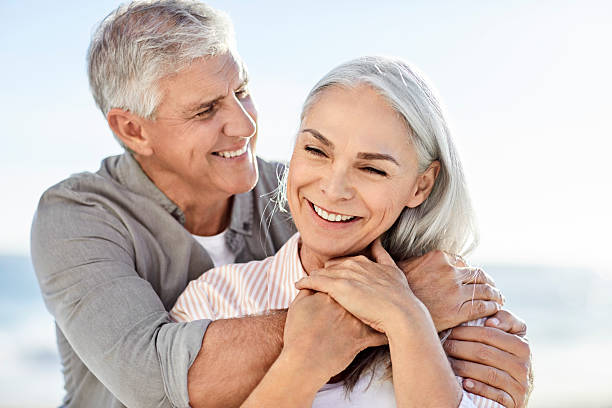 istock Smiling mature man embracing partner at beach 2213680110