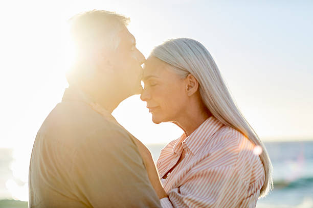 istock Mature man kissing female partner at beach 2213680149