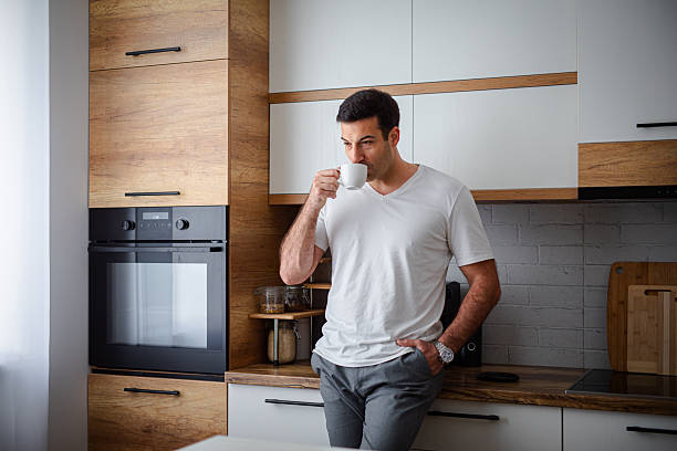 istock Man enjoying fresh aromatic coffee in kitchen 2213681041