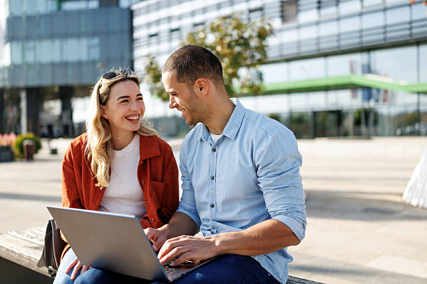 istock Young business couple using laptop together outside office building 2213681107