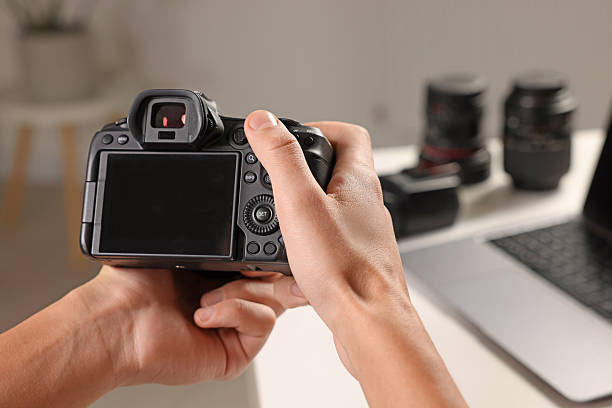 istock Photographer with professional camera at white desk indoors, closeup 2213681321