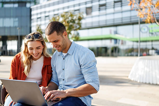 istock Young business couple using laptop together outside office building 2213681473