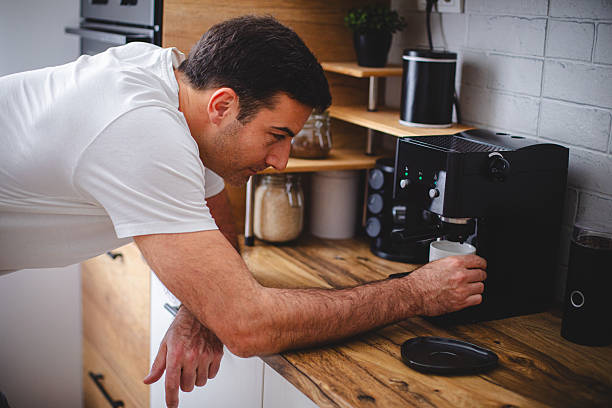 istock Man standing in the kitchen preparing him self coffee in the morning 2213681591