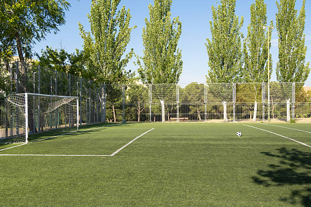 istock Soccer ball sitting on empty field on sunny day 2213684389