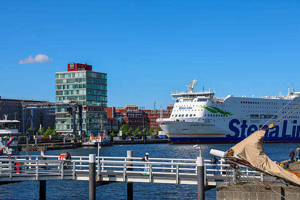 Kiel, Germany - 05 May 2025: Cruiseferry Stena Germanica moored in Kiel harbor on a sunny day, with a glimpse of the city's modern architecture