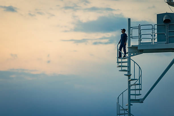 An engineer is repairing a satellite receiver under the sunset.