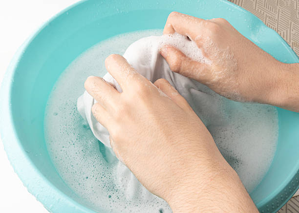 istock Hand laundry washing clothes in blue plastic basin 2213693273