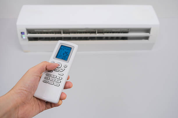 istock Man's hand using remote control open The air conditioner is cooled to 25 degrees Celsius in his bedroom. Health concepts and energy savings 2213694384