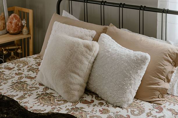 istock Cozy bedroom with fluffy pillows and patterned bedding. 2213695225
