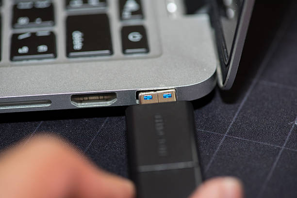istock Hand inserting Flash drive memory drive plugged into a computer laptop port. 2213695995