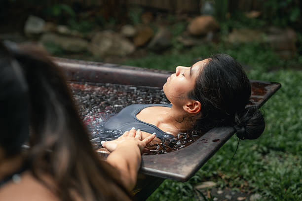 Women practicing necessary steps for ice bath therapy, pinching their noses with their fingers to hold their breath