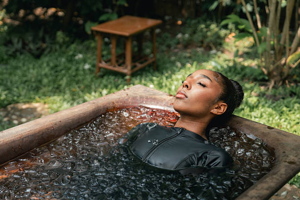 Women practicing necessary steps for ice bath therapy, pinching their noses with their fingers to hold their breath