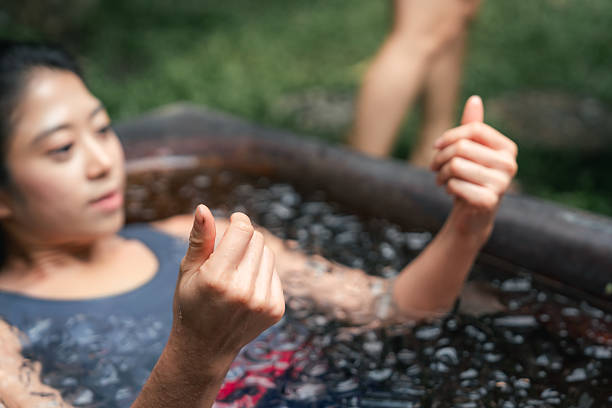 istock Women practicing necessary steps for ice bath therapy, pinching their noses with their fingers to hold their breath 2213698393
