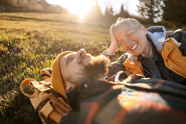 istock Couple of hikers relaxing on grass under sunlight 2213700519