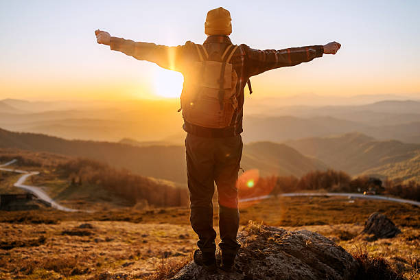 istock Back view man with arms wide open in mountain sunset 2213703790