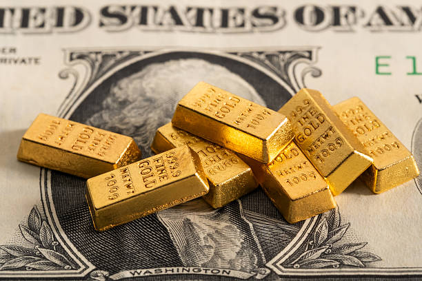 istock Gold bars on US dollar bill 2213704381