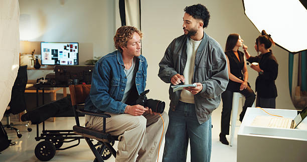 istock Talking, photographer and people with tablet in studio for editing software, photoshoot and production. Camera, creative director and men with digital tech for magazine catalogue, photography or film 2213705318