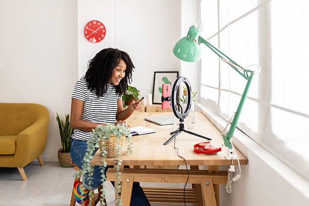 istock Young content creator woman live streaming at home using mobile phone. 2213709403