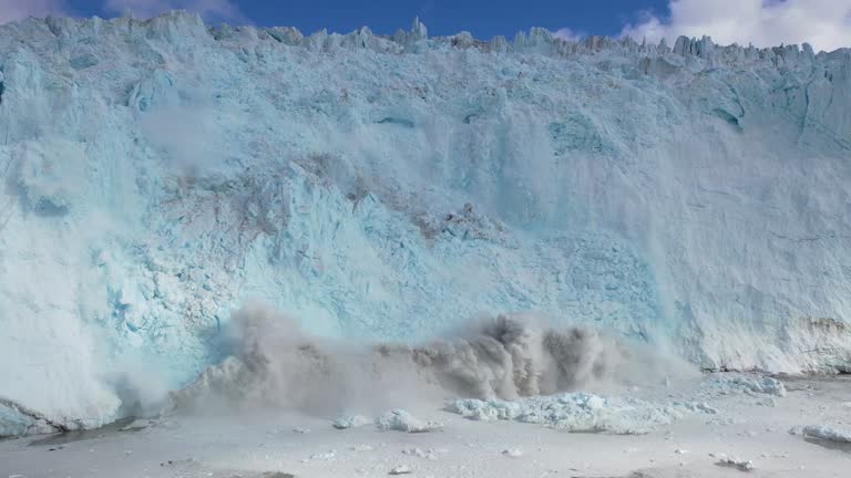 Massive Eqi Glacier calving, creating thundering ice wave and billowing dust cloud against stark Arctic wilderness near Disko Bay, Greenland