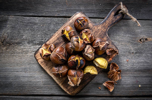 istock Roasted chestnuts on wooden background 2213711308