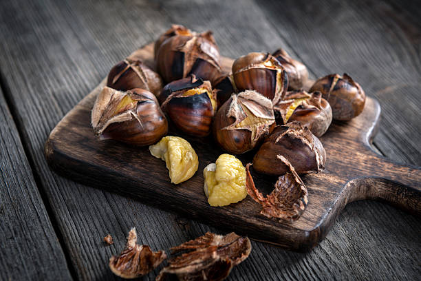istock Roasted chestnuts on wooden background 2213711315