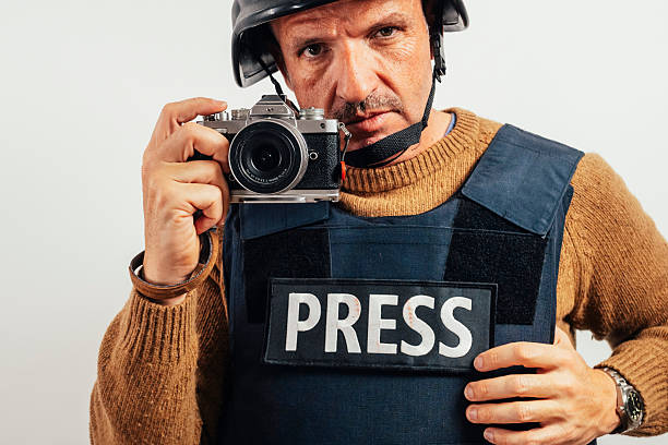 Reporter in bulletproof vest with a camera.