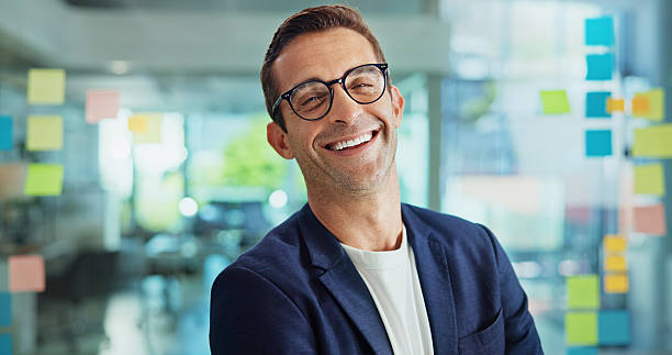 istock Mature business man, portrait and office with glass wall, notes or smile for problem solving at startup. Person, pride and happy by window, career and mind map for job at creative agency 2213725162