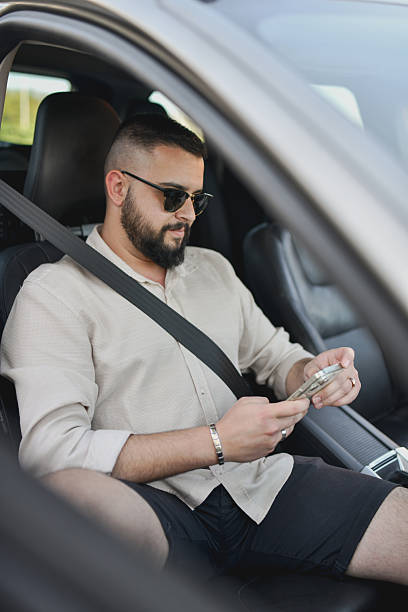istock Modern Man Typing on Phone While Parked and Waiting for Friend 2213728166