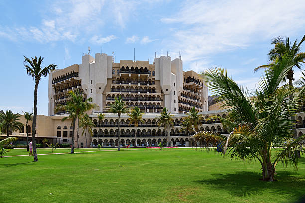 Muscat, Oman - April 8, 2025: Building of Al Bustan Palace, a Ritz-Carlton Hotel. Beautiful palace with amazing facilities - restaurants, spa, pools, sport center. Amazing location between Al Hajar mountains and the Golf of Oman. Arabian Peninsula