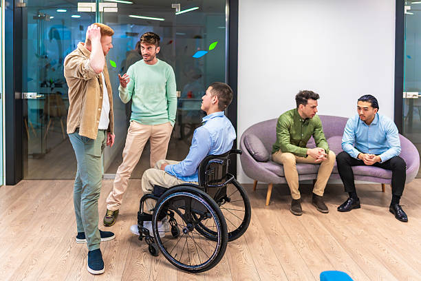 istock Diverse businesspeople discussing in modern office with disabled colleague 2213730091