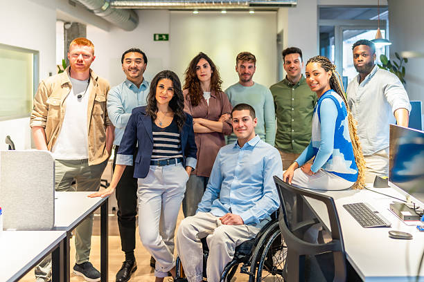 istock Diverse business team posing in modern office with disabled colleague 2213730205