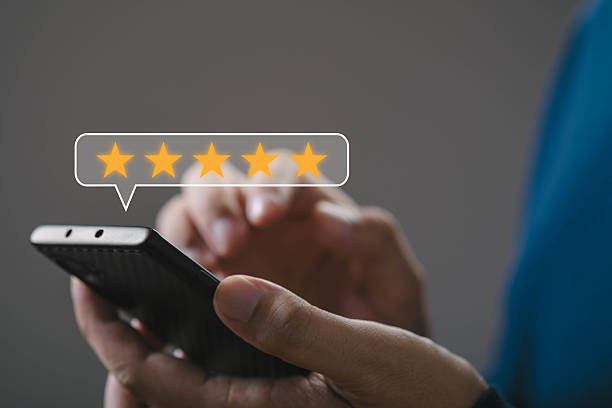 istock A person's hand holding a smartphone while leaving a five-star review. The digital display highlights a positive feedback experience in the modern tech world. 2213730448