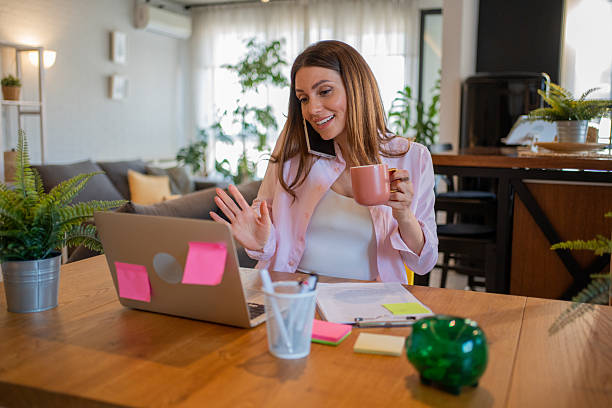istock Businesswoman working from home having a video call and drinking coffee 2213730700
