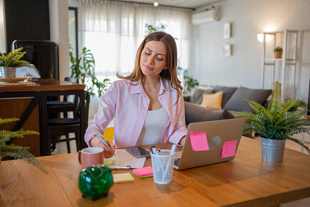 istock Focused freelancer working from home on her laptop and taking notes 2213730902