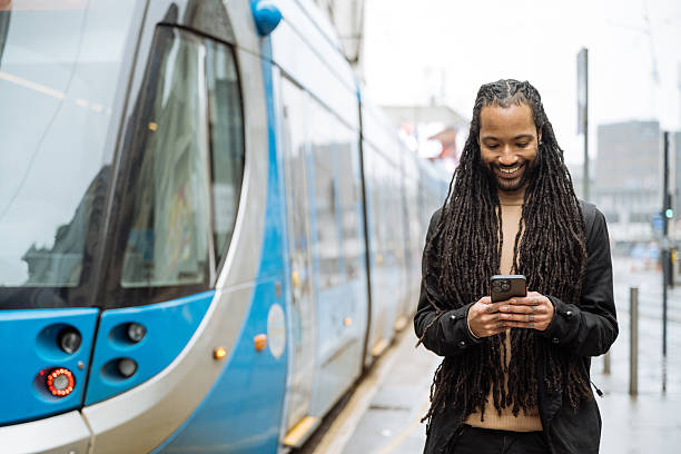 istock Black tourist with dreadlocks visiting city on rainy day and using smart phone for text messaging 2213735761