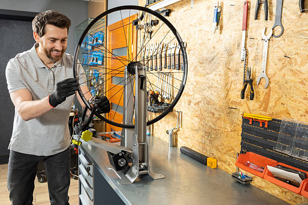 istock Mechanic in black gloves holding bicycle wheel 2213736629