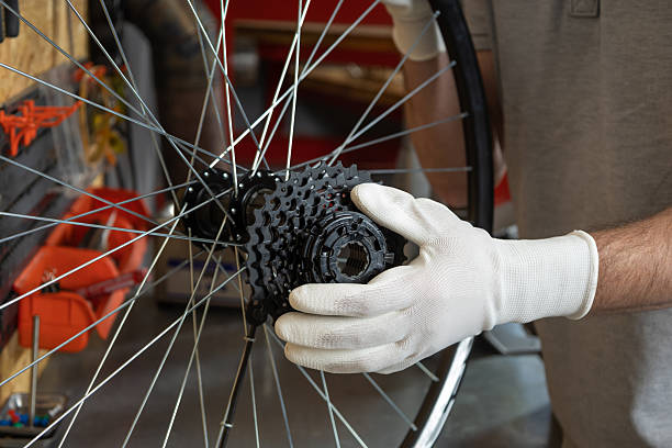 istock Mechanic in white gloves holding bicycle wheel 2213736711