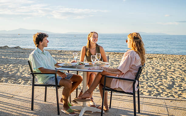 istock Young tourists enjoying seaside lunch at sunset 2213742924