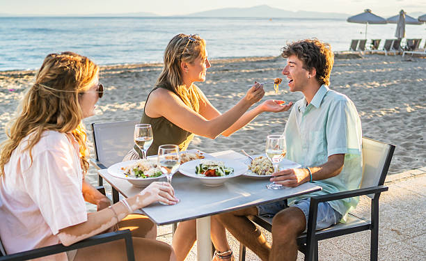 istock Family enjoying dinner on the beach at sunset 2213745299